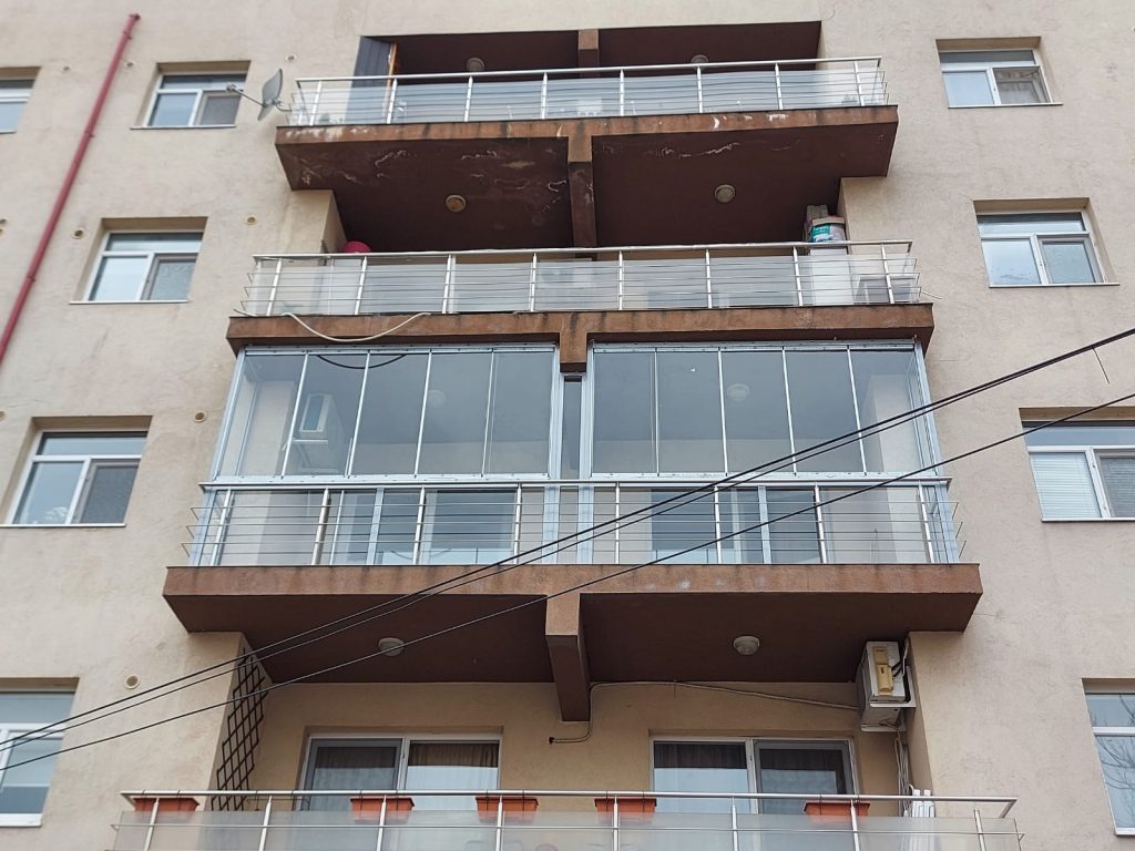 Balcon într-un bloc vechi închis cu geamuri glisante