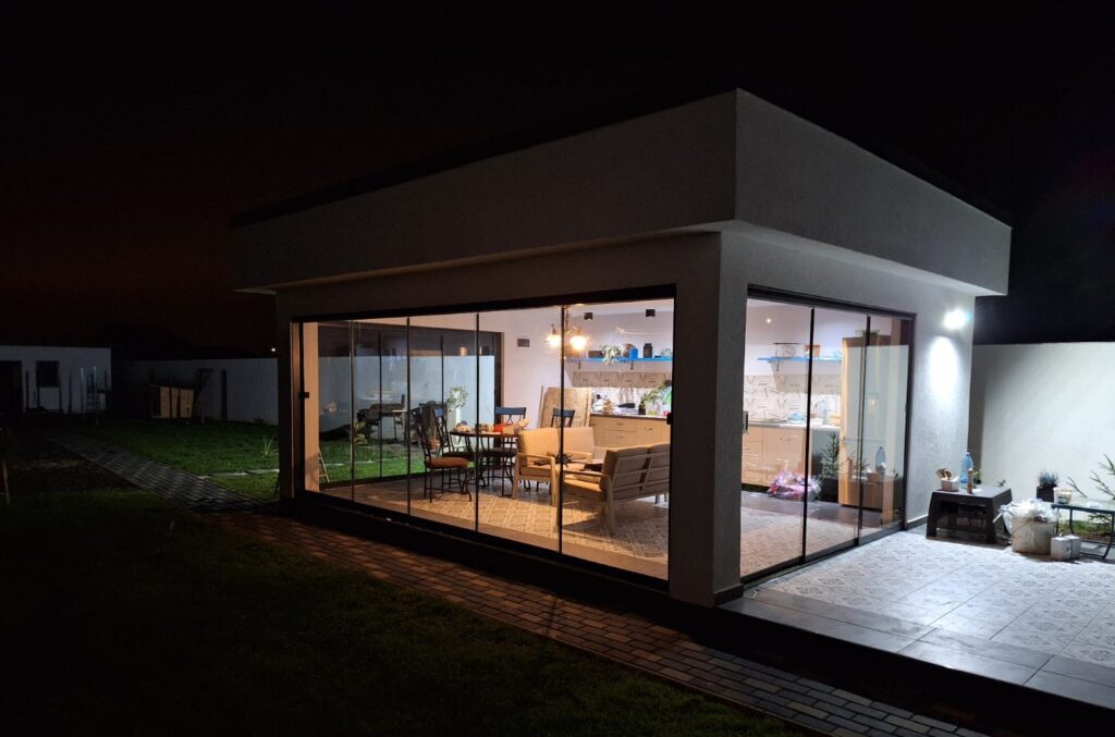 Terasă amenajată cu sistem de închidere cu geamuri glisante din sticlă securizată